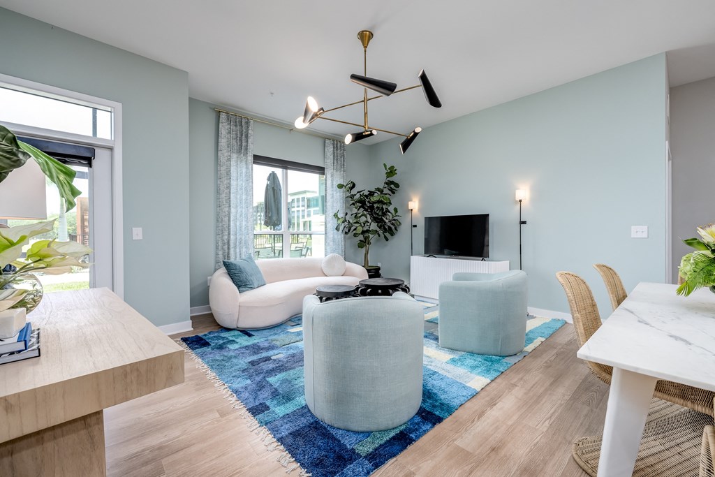 a living room with light blue walls and a blue rug at Ironwood Flats, Florida, 33511