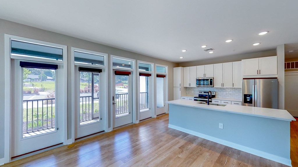 a kitchen with white cabinets and a blue island with a white counter top at Ironwood Flats, Brandon