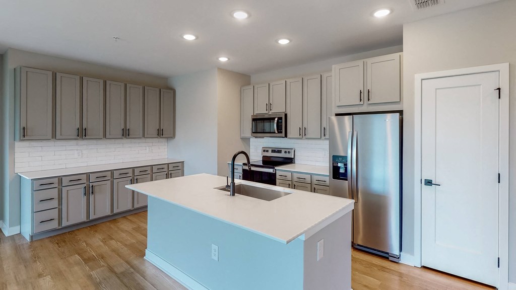 a kitchen with a large center island with a sink and a refrigerator at Ironwood Flats, Brandon, 33511