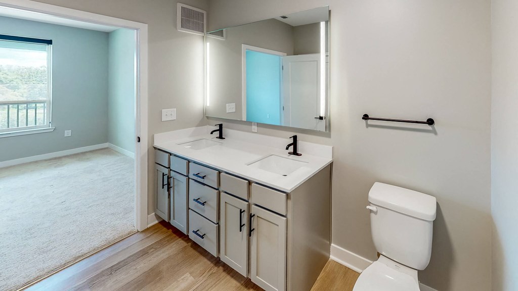 a bathroom with a toilet sink and mirror at Ironwood Flats, Florida, 33511