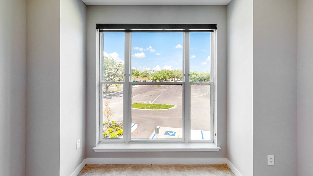 an empty room with a large window and a view of a parking lot at Ironwood Flats, Brandon, Florida