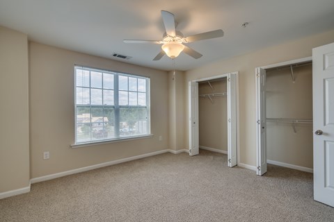 A room with a ceiling fan and a window.