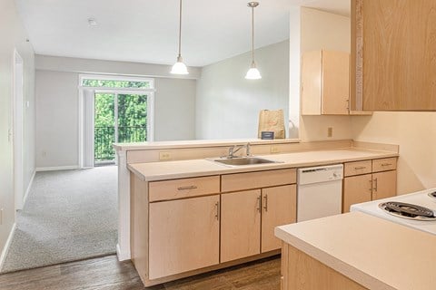 A kitchen with wooden cabinets and a white counter top.