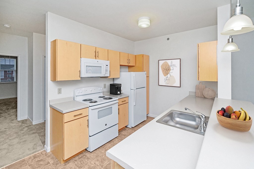 a two bedroom kitchen with white appliances and wooden cabinets at Limestone Creek Apartment Homes, Madison, AL
