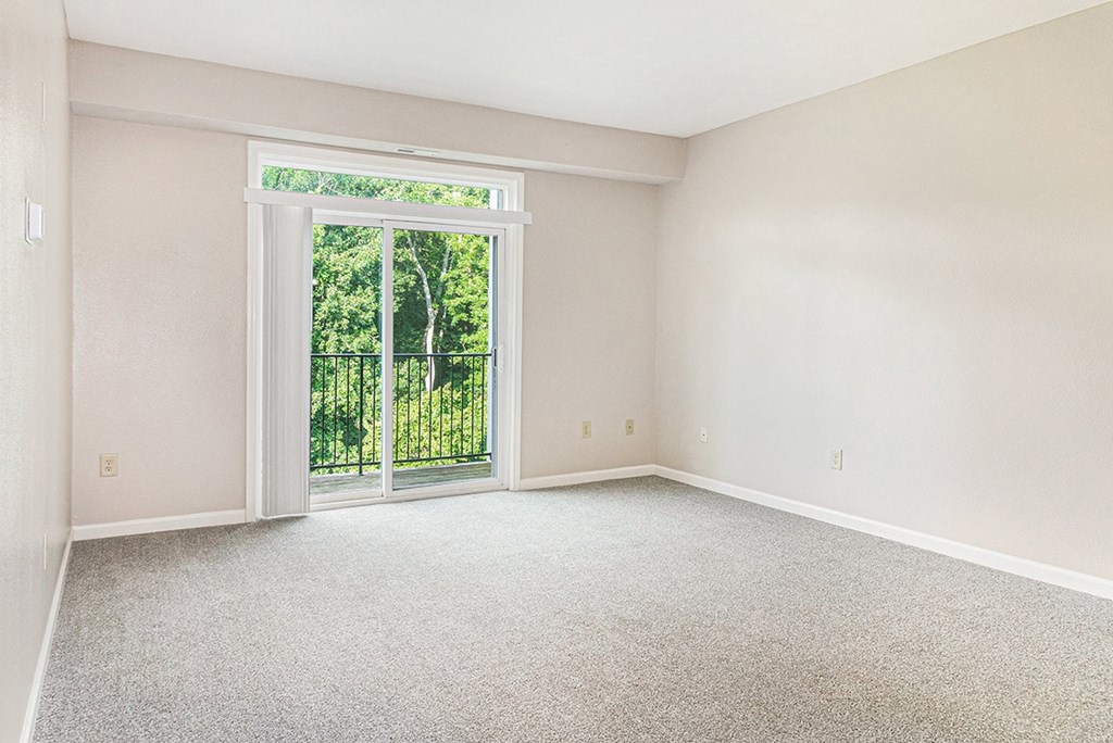 A living room with a carpeted floor and a 9 foot ceiling at Limestone Creek Apartment Homes, Madison, AL