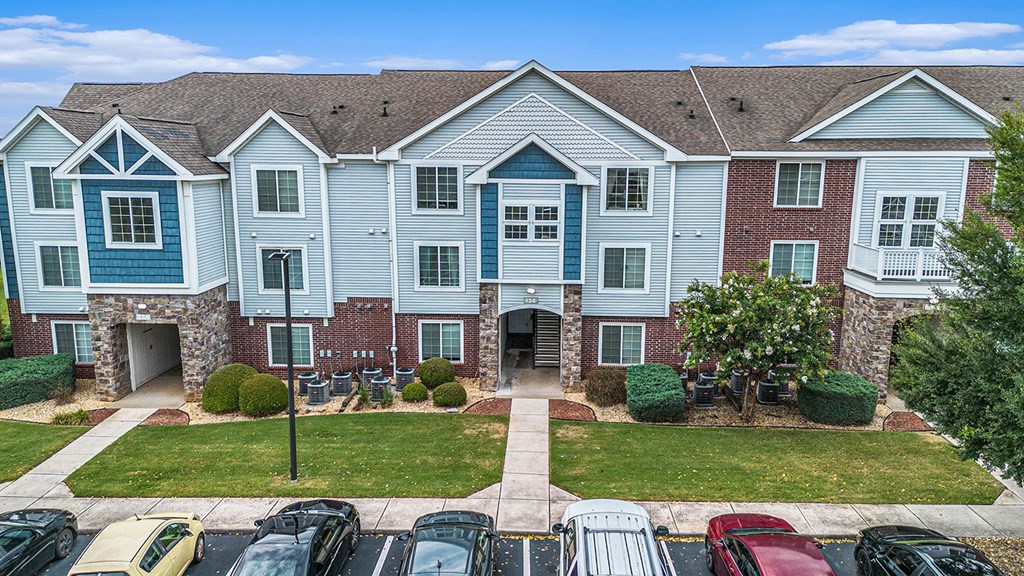 A large apartment building with a sidewalk in front at Limestone Creek Apartment Homes, Madison, AL