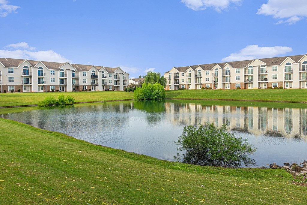 A row of apartments are reflected in the water of a pond at Limestone Creek Apartment Homes, Madison, AL