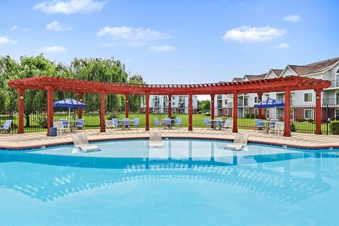 A red pergola is over a pool.