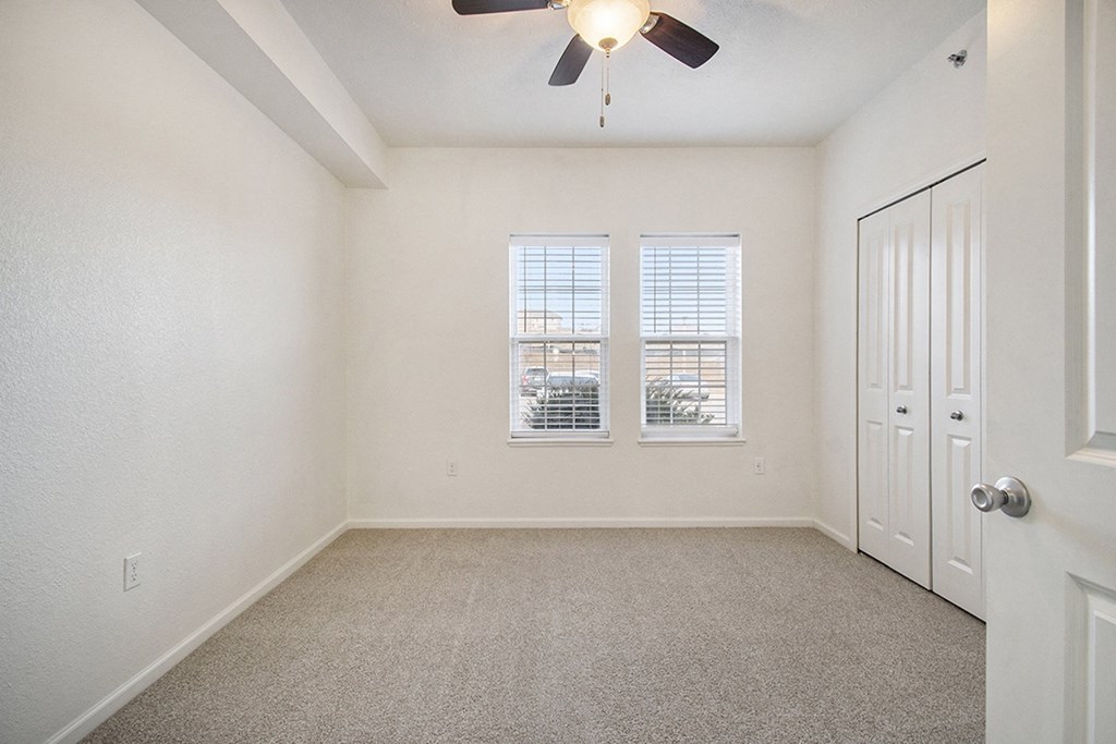 A bedroom with a ceiling fan and two windows at Lynbrook Apartments and Townhomes, Elkhorn, NE, 68022