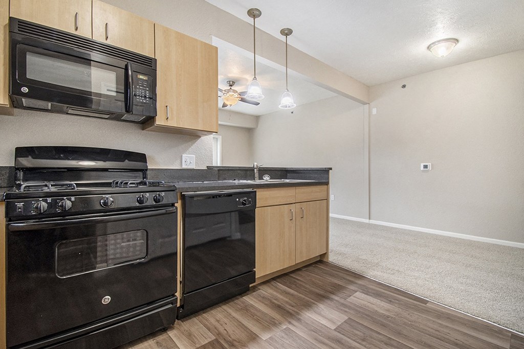 A kitchen with black appliances and hard surface flooring at Lynbrook Apartments and Townhomes, Elkhorn, NE, 68022