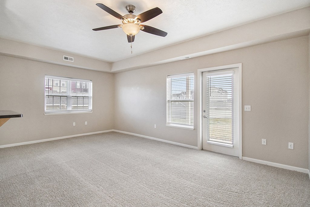 An end style living room with a ceiling fan and windows at Lynbrook Apartments and Townhomes, Elkhorn, NE, 68022