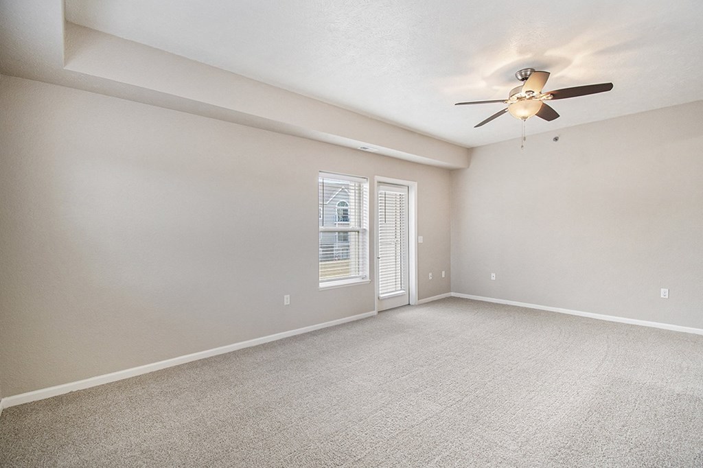 An enlarged living room with a ceiling fan and plush carpeting at Lynbrook Apartments and Townhomes, Elkhorn, NE, 68022