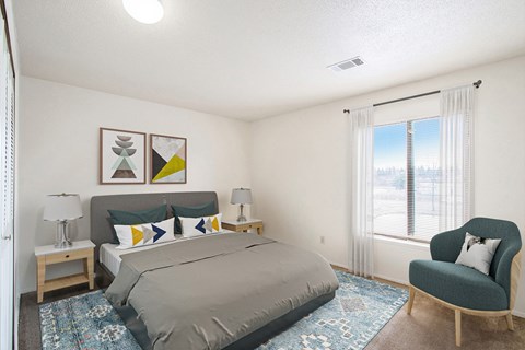 A bedroom with a large bed and a chair.