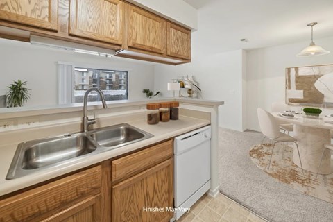 A kitchen with wooden cabinets and a white dishwasher.