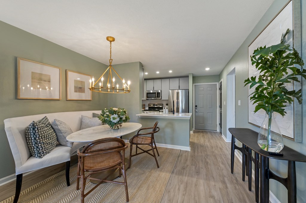 a dining area with a table and chairs and a kitchen in the background at Latitudes Apartments, Indianapolis, IN, 46237