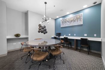 a conference room with a blue accent wall and a round table with chairs at Montgomery Place Apartments, Montgomery, Illinois