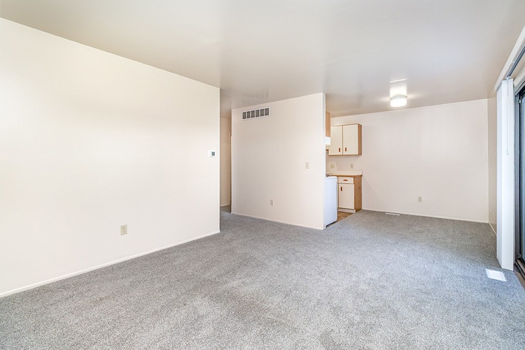 A spacious living to dining room with a kitchen around the corner at Mount Royal Townhomes, Michigan
