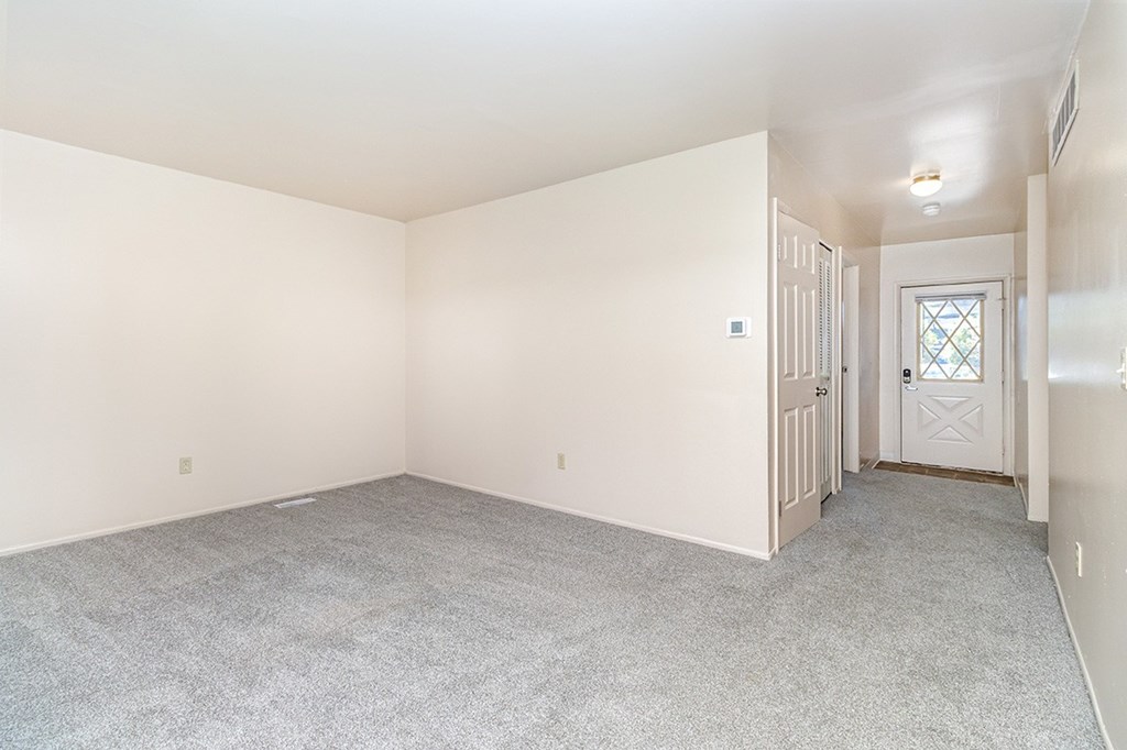 An entryway and living room with a carpeted floor at Mount Royal Townhomes, Michigan