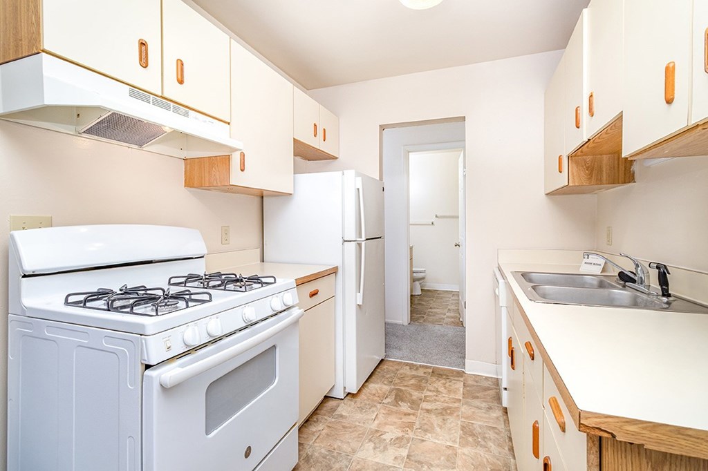 A kitchen with a white stove and dishwasher at Mount Royal Townhomes, Michigan