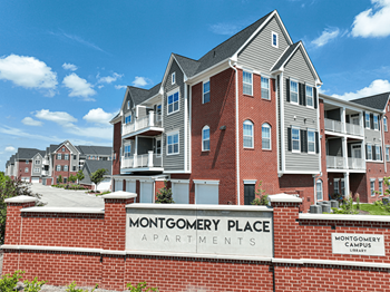 a large brick building with a sign that reads montgomery place apartments at Montgomery Place Apartments, Illinois, 60538