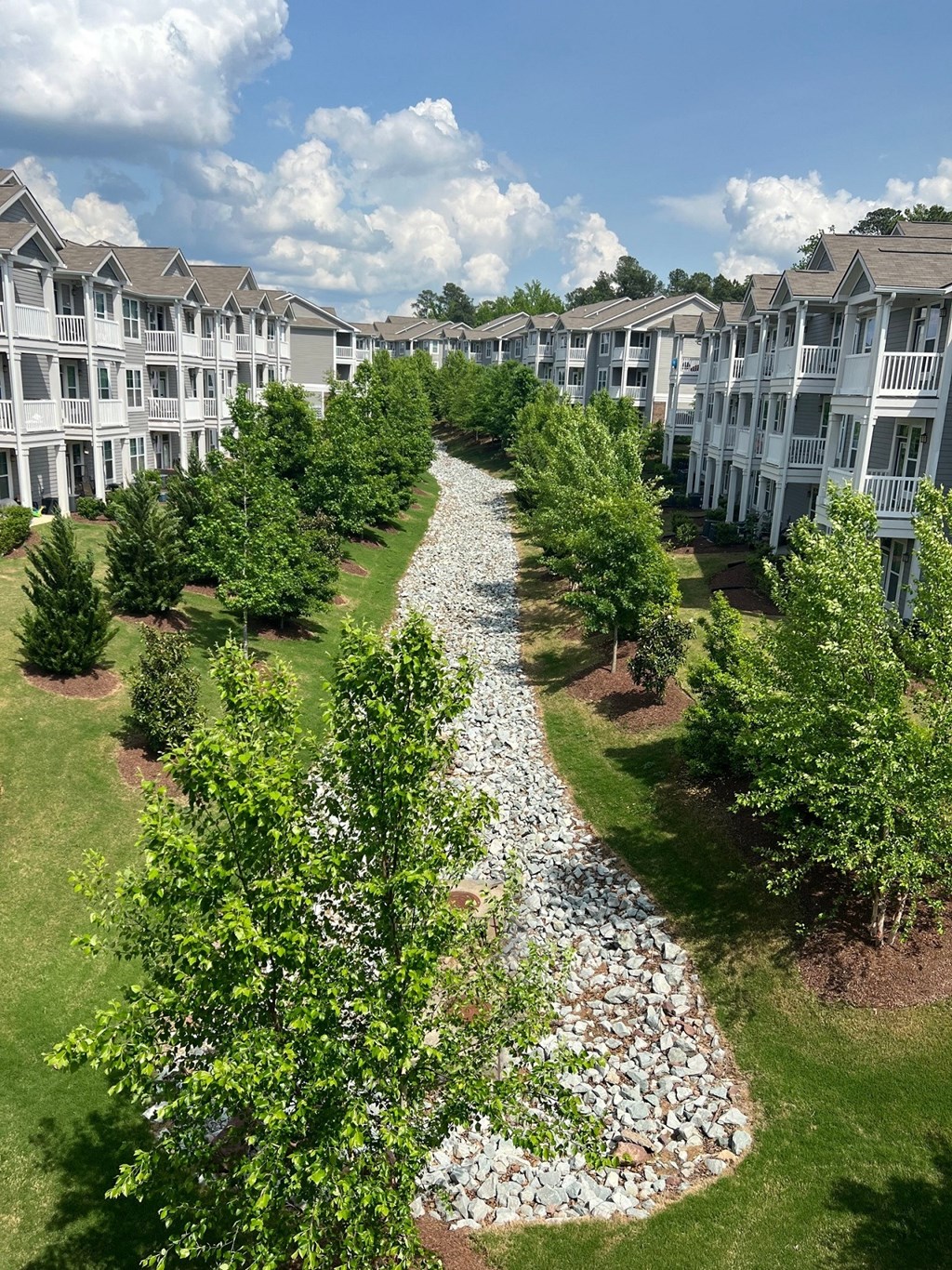 an aerial view of an apartment complex with a gravel path and trees  at Avellan Springs Apartments, Morrisville, NC, 27560
