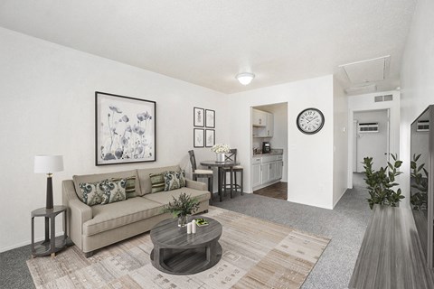 A living room with a couch, coffee table, and a painting on the wall.