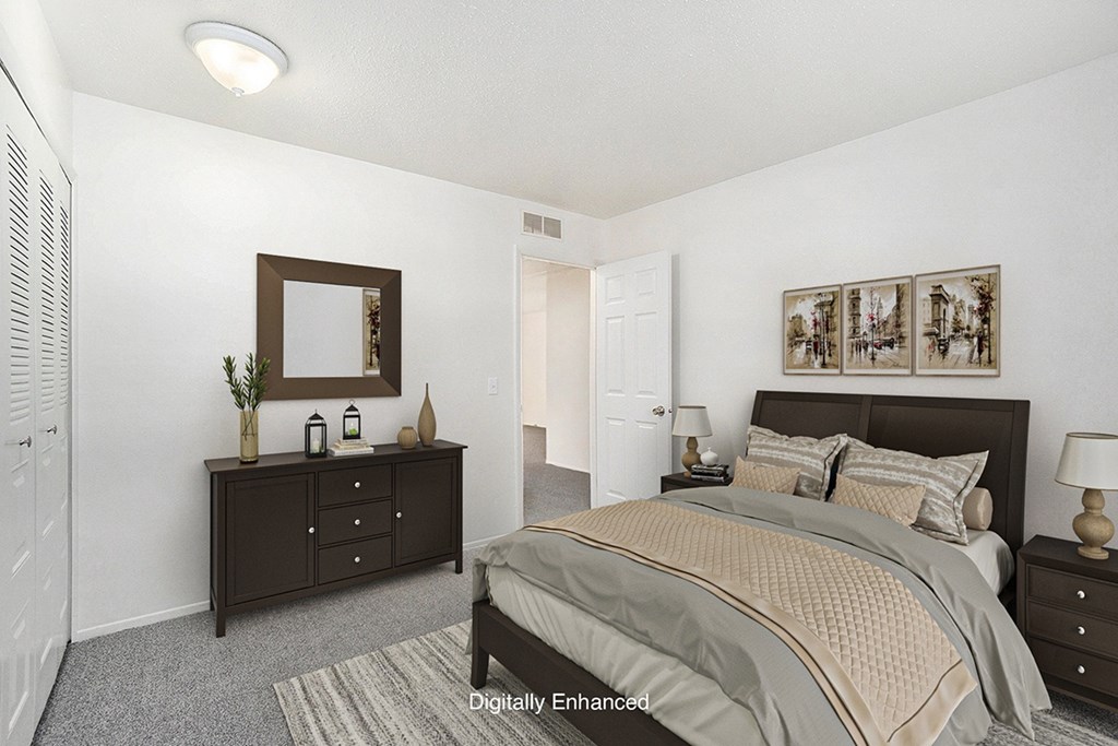 A bedroom with a bed, dresser, and mirror at Newport Village Apartments, Portage, MI