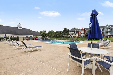 A poolside area with chairs and tables is shown.