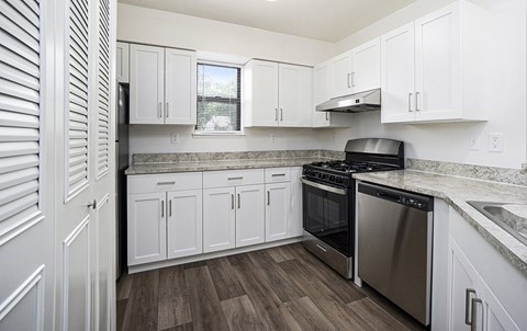 A kitchen with white cabinets and a black stove top oven.