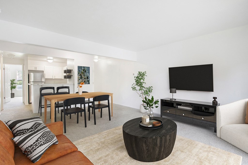A modern living room with a wooden coffee table and a flat screen TV at North Pointe Apartments, Elkhart