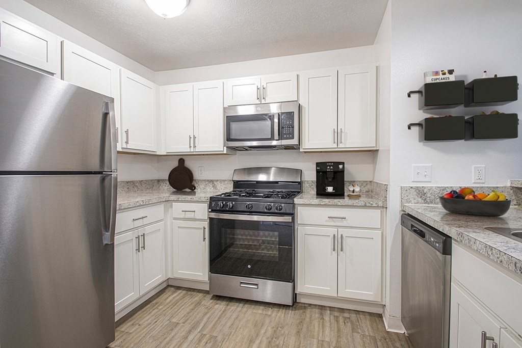 A kitchen with white cabinets and a stainless steel appliances at North Pointe Apartments, Elkhart