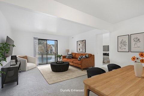A living room with a brown sofa and a wooden table.