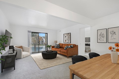 A living room with a brown sofa and a wooden table.