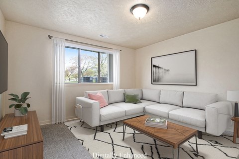 A living room with a white couch, a coffee table, and a large window at Old Farm Apartments, Elkhart, Indiana