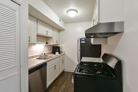 A stainless steel stove in a kitchen with white cabinets at Old Monterey Apartments, Missouri, 65807