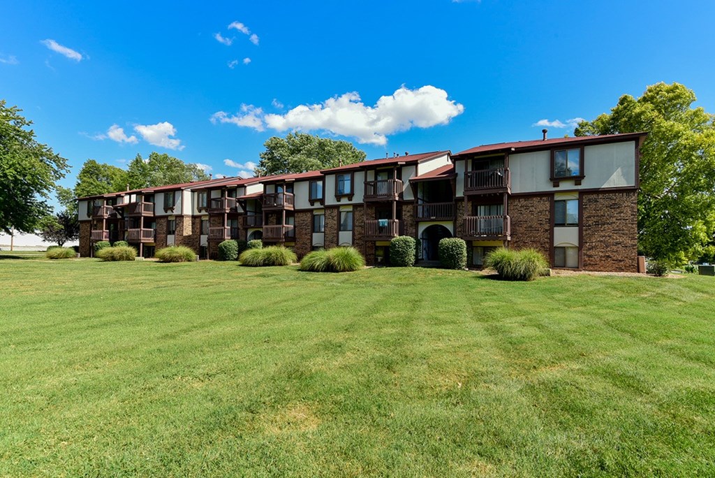 An apartment building with a green lawn in front at Old Monterey Apartments, Springfield, MO