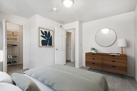 A bedroom with a grey bed and a walk-in closet at Orchard Lakes Apartments, Toledo, 43615
