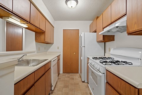 the preserve at ballantyne commons apartment kitchen with white appliances and wooden cabinets