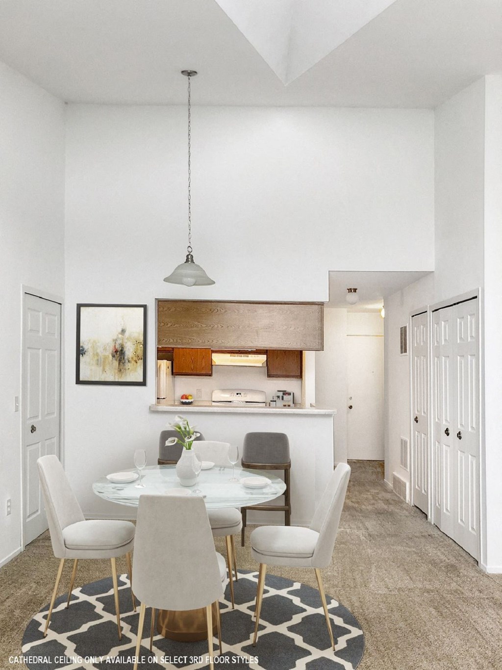 a dining area with a white table and chairs and a kitchen in the background  at Northport Apartments, Macomb, MI, 48044
