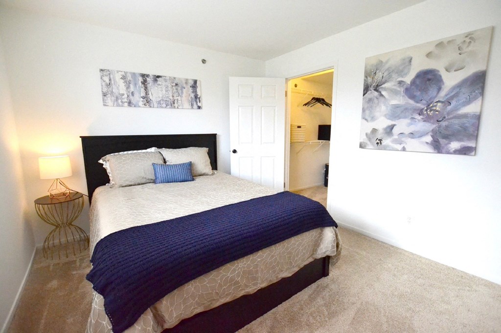 a bedroom with a bed and a nightstand at Northport Apartments, Macomb, MI, 48044