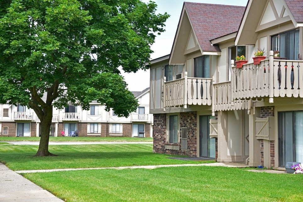 a picture of an apartment complex with a tree in the foreground at Beacon Hill and Great Oaks Apartments, Rockford