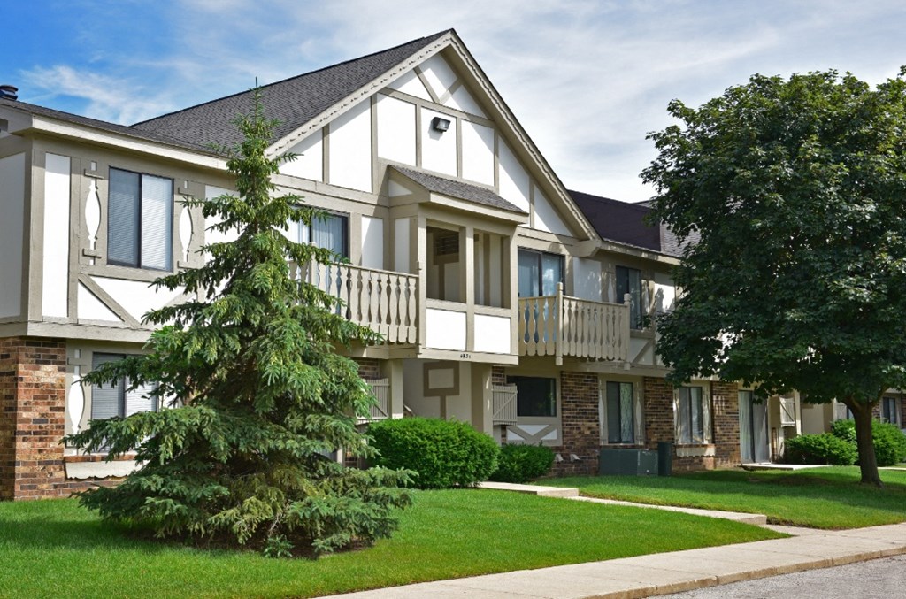 an apartment building with two large trees in front of it at Beacon Hill and Great Oaks Apartments, Rockford, IL, 61109