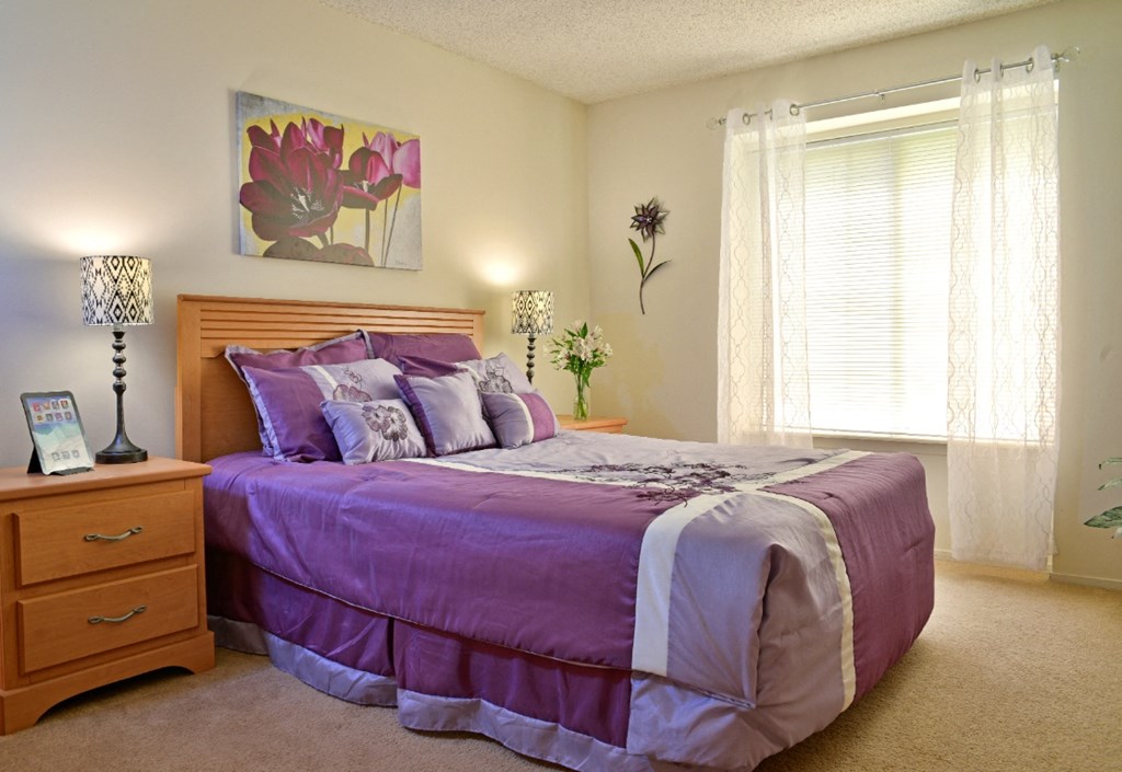 a bedroom with a bed and a dresser at Beacon Hill and Great Oaks Apartments, Rockford, IL, 61109
