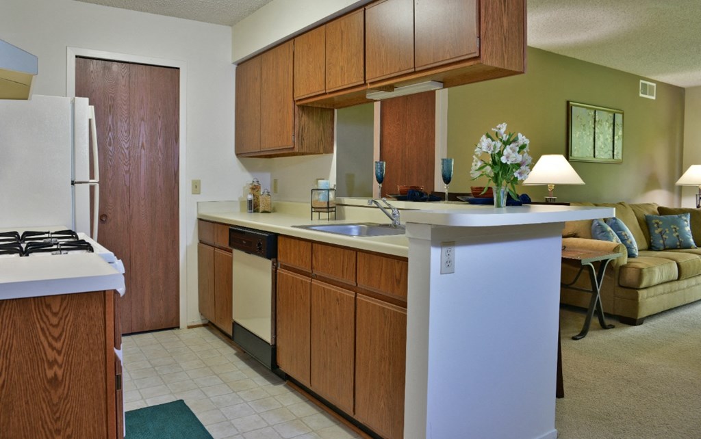 a kitchen with wooden cabinets and a white counter top at Beacon Hill and Great Oaks Apartments, Illinois, 61109