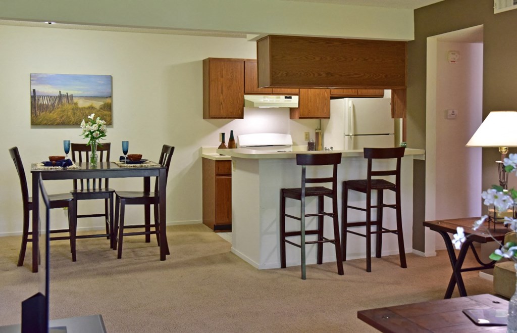 an open kitchen and dining area with a dining table and chairs at Beacon Hill and Great Oaks Apartments, Rockford, IL