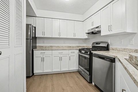 A kitchen with white cabinets and stainless steel appliances.