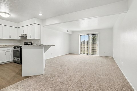 A spacious kitchen with white cabinets and a countertop.