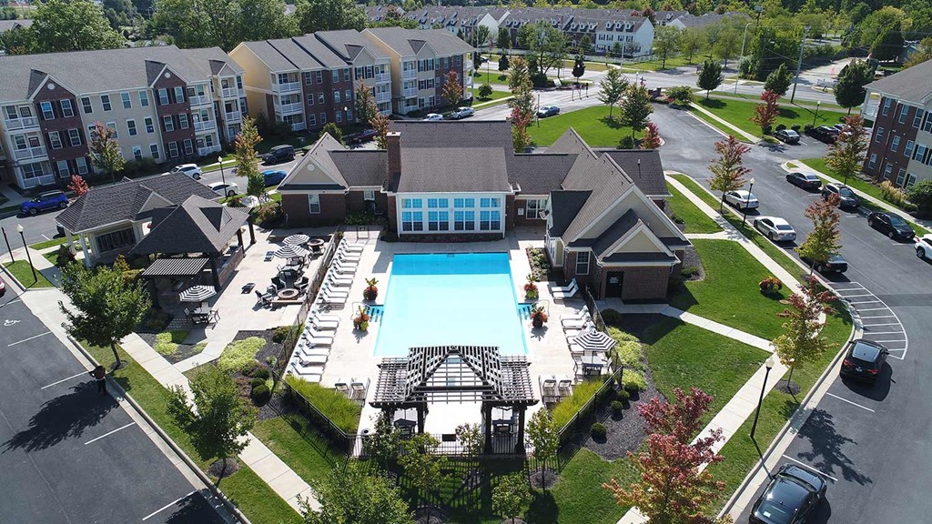 an aerial view of a large swimming pool in front of a building at The Avenue at Polaris Apartments, Columbus, Ohio