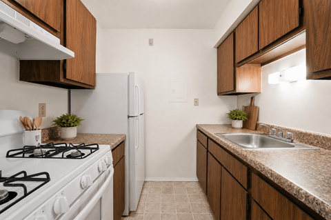 A kitchen with a white gas stove and a white refrigerator.