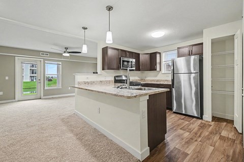 A kitchen with a breakfast bar, pantry and window at The Reserve at The Reserve at Destination Pointe in Grimes, IA 50111
